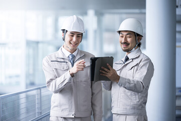 Smiling workers checking and thinking about inspections and maintenance maintenance in bright warehouses and factories.