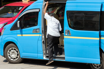 A man get out of the minivan - shared taxi, a traditional public transport of people in Thailand