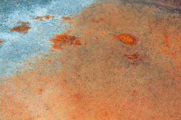 Rusty metal background with fragments of paint .