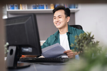 Photo of young Asian businessman working at office