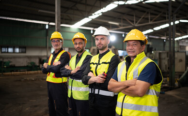Portrait of team of engineers and technicians that is ready for repairing old machinery to return to normal operation in the company's old machinery warehouse