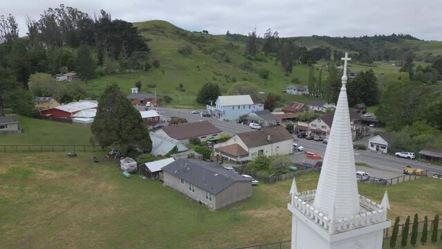 aerial view of town of Bodega, California arcing backward over church