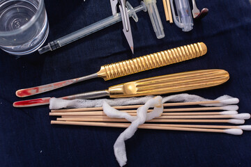 Bloodied nasal rasps and cotton swabs on the operating table during a rhinoplasty procedure or cosmetic surgery.