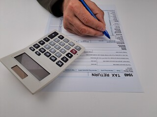 American Tax Return Form 1040, US Individual Tax Return, desk with operator at work.