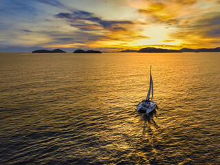 Aerial view of a catamaran on the andaman sea. Sunset sailing in Phuket, Thailand. - obrazy, fototapety, plakaty