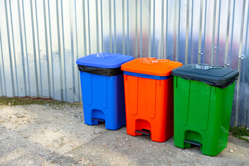 Color garbage bins in the city street on metal background