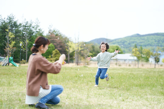 公園でシャボン玉で遊ぶ親子
