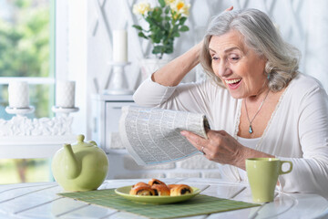 Portrait of senior woman reading newspaper