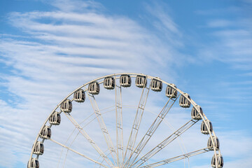 Fototapeta premium A view of a the top half of a Ferris Wheel against to cloudy sky.