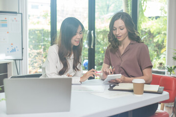 Obraz premium Two Businesswomen Using Laptop In Boardroom Meeting