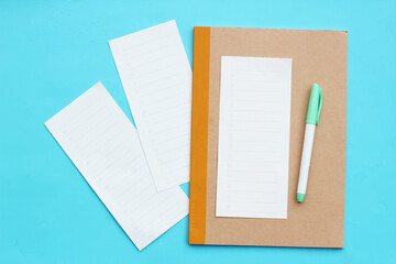 To do list paper with notebook and pen on blue background.