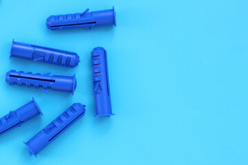 Plastic anchors for steel screws on blue background.