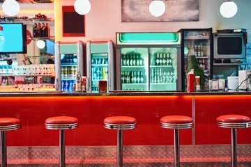 Foto op Plexiglas Retro, vintage and stools with interior in a diner, restaurant or cafeteria with funky decor. Trendy, old school and chairs by a counter or bar in groovy, vibrant and stylish old fashioned empty cafe © Camerene P/peopleimages.com