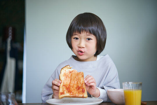 いちごジャムのトーストを食べる女の子