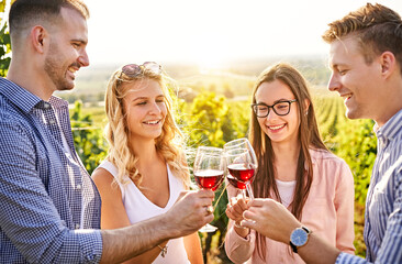 Young friends having fun outdoors - Happy people enjoying harvest time together at farmhouse winery countryside - Tasting red wine at vineyard