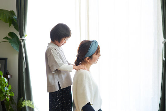 母の肩を揉む日本の娘