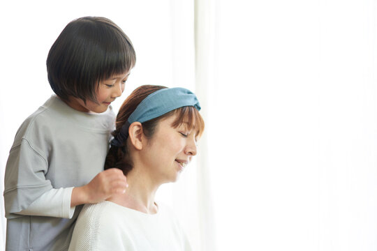 母の肩を揉む日本の娘