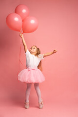 Fototapeta na wymiar little girl in a white t-shirt and a pink tutu with balloons on pink background. Ready to fly high