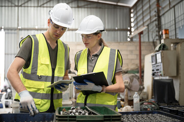 Caucasian engineer man and woman engineer checking spare part woman at spare factory	