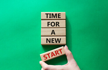 Time for a new start symbol. Wooden blocks with words Time for a new start. Beautiful green...