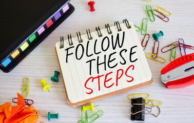 Follow these steps symbol. Concept words Follow these steps on white notebook. Beautiful wooden background. Business and Follow these steps concept. Copy space.