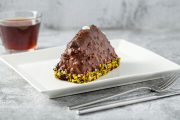 Dessert Cake from Malaga on stone table. Cake with banana inside, covered with chocolate sauce and hazelnuts