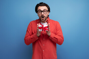 joyful cute young guy with chic black hair received a gift