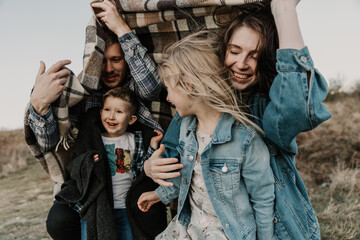 happy family spends time in nature. Son, daughter, dad and mom are hugging and laughing