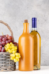 Ripe grape in basket and wine bottles