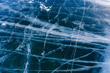 Abstract background texture of blue ice with cracks, top view of Lake Baikal