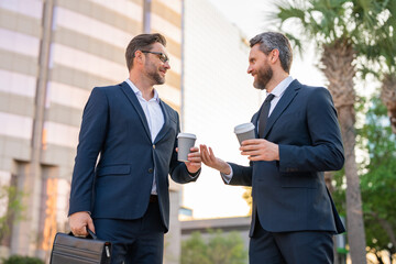 Business communication. Two business men talking on coffee break outdoors. Two diverse businessmen talking together. Colleagues discussing and thinking about project. Talking between two business men.