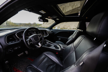 Fototapeta na wymiar Interior of the muscle car. Black leather chairs.