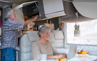 Happy retired caucasian couple enjoying freedom and alternative lifestyle traveling in camper van....