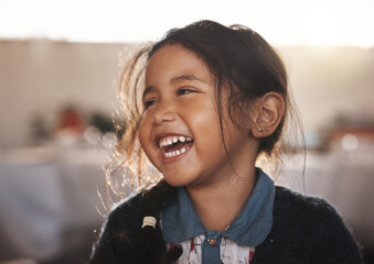 Happy, kid and girl laughing in a living room, playing and having fun in her home. Child,...