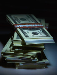 Stacks of US Dollar bills against dark background