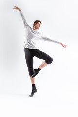 Obraz premium One Caucasian Handsome Young Man Dancing Ballet Posing in Dance Pose with Lifted hands in White Shirt On White.