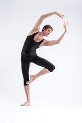 Naklejka premium One Professional Male Ballet Dancer Young Man in Black Dance Tights Suit Posing in Ballanced Dance Pose in Studio.
