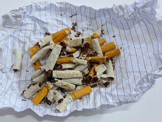 Close-up of broken cigarettes on paper on isolated background 