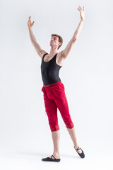 Obraz premium Stretching of Concentrated Contemporary Ballet Dancer Flexible Athletic Man Posing in Red Tights in Ballanced Dance Pose on White.