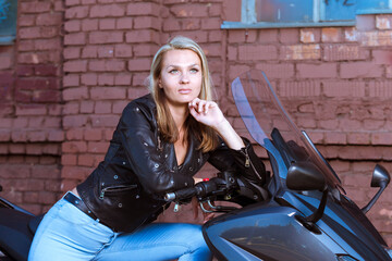 Obraz na płótnie Canvas Road Motorcycling Adventures. Winsome Female Biker Girl In leather Jacket Posing on New Modern Motorbike Outdoors Against Grunge