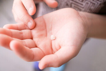 乳歯と子供の手。永久歯への生え変わり。小学生低学年の男の子。