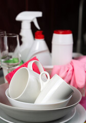 Clean dishes and on the background detergents on the table at the kitchen. Close-up. Selective focus.