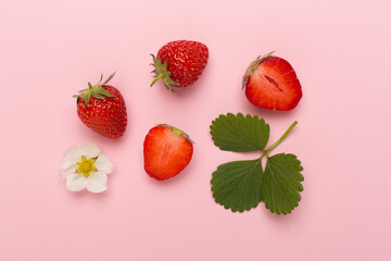 Strawberries with leaves on color background, top view