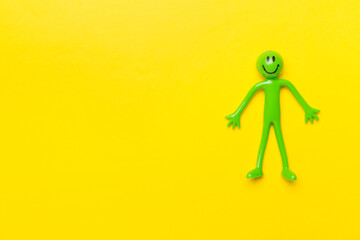 Human figure toy on color background, top view