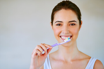 Woman, toothbrush and toothpaste brushing teeth in bathroom for health, happiness and wellness in...