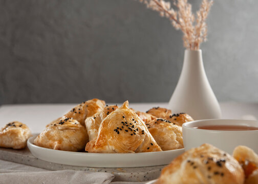 Puff hot samsa with pumpkin and hot tea. Table setting in European style.