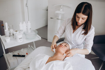 Cosmetologist is a professional with a patient in the beauty salon