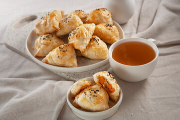 Puff hot samsa with pumpkin and hot tea. Table setting in European style.