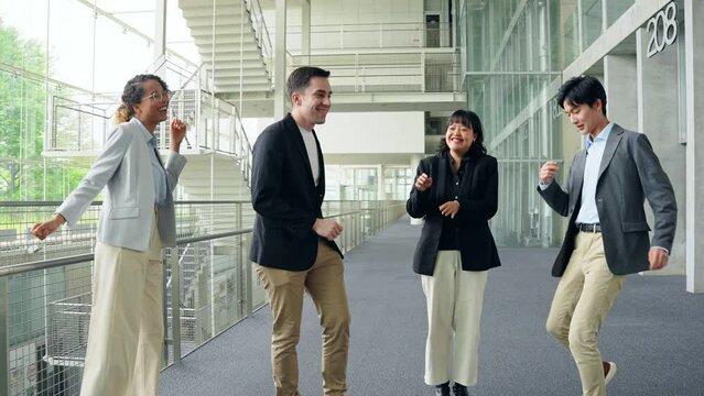 Multinational business group dancing in office.