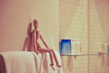 浴室のタオルの上に座るマネキン人形